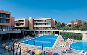 西尔米奥奈Hotel Holiday的一座带游泳池和椅子的酒店和一座建筑