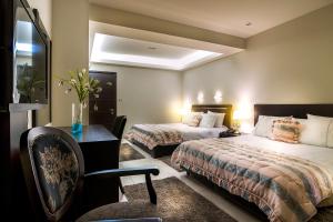 卡斯托里亚Pansion Zafeiriou的酒店客房 - 带两张床、一张桌子和一把椅子