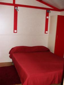 蒙塔吉尔Parque de Campismo Orbitur Montargil的一间卧室配有红色的床和红色毯子