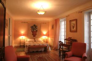 乌瑞基尼Erlande Baïta的一间卧室配有一张床、两把椅子和两盏灯。