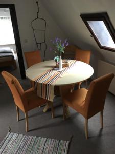 莱比锡Ferienhaus zentral & grün的餐桌,椅子和花瓶