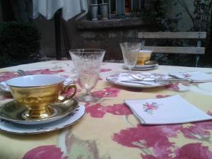 阿尔勒维哥波恩德B&B酒店的桌子上放着杯子,盘子和玻璃杯