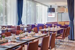 策勒策勒城际酒店的餐厅设有桌椅和蓝色窗帘