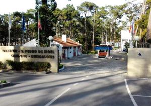 圣佩罗德姆Parque De Campismo Orbitur Sao Pedro De Moel的大楼前有标志的停车场