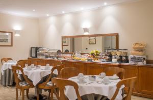 佛罗伦萨黛安娜帕克酒店的一间带桌子和柜台的餐厅,提供自助餐