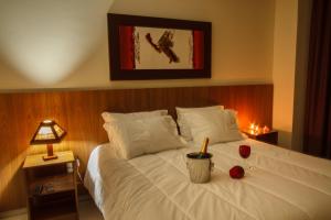 布鲁马迪纽山城酒店的卧室配有一张带蜡烛的白色床