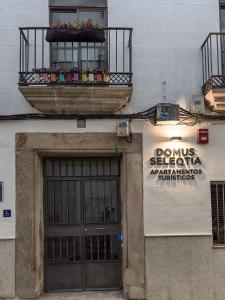卡塞雷斯Apartamentos Turísticos Domus Seleqtia Plaza Mayor的一座有门和标志的建筑