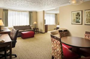 路易斯威尔路易斯维尔机场博览中心皇冠假日酒店的酒店客房设有带桌椅的起居区。