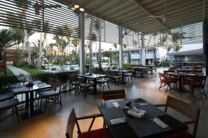 皮乌拉皮乌拉安迪纳优质酒店的一间空餐厅,配有桌椅和窗户