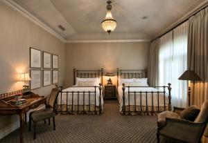 圣伊内斯The Genevieve的一间卧室配有两张床、一张桌子和一张沙发