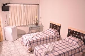 帕尔马斯卡平杜尔拉多酒店的客房设有两张床、一张桌子和电视。