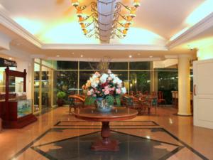 Tuban图班特罗皮斯酒店的大堂设有一张桌子和花瓶