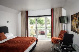 基督城格兰奇汽车旅馆的酒店的客房 - 带一张床、椅子和窗户
