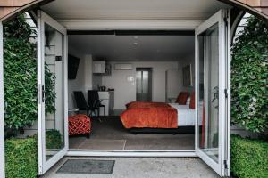 基督城格兰奇汽车旅馆的一间卧室设有一张床和一个滑动玻璃门