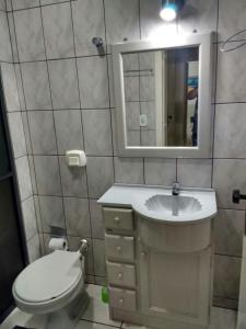 伊塔佩马Apartamento 3 quartos的一间带卫生间、水槽和镜子的浴室