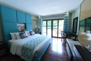 Colongcocon图嘎维考夫度假酒店的一间带大床的卧室和一个阳台