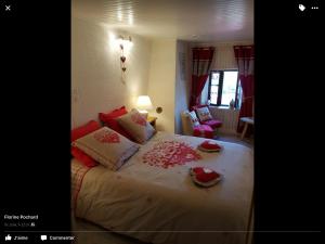 Le Haut-du-Them乐菲美迪拉豪特住宿加早餐旅馆的一间卧室配有一张带红色枕头的大床
