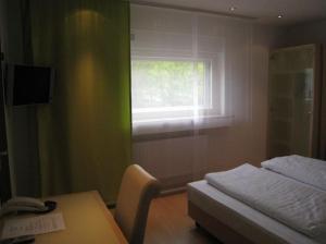 蒂宾根巴巴丽娜酒店的一间卧室配有一张床、一张桌子和一个窗户。