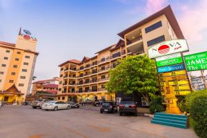 芭堤雅市中心Nova Park Hotel Pattaya的一条在大楼前停放汽车的街道