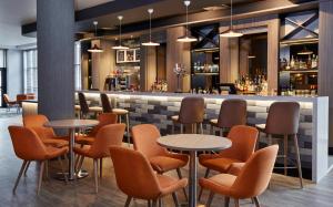 诺丁汉Leonardo Hotel Nottingham的一间带桌椅的餐厅和一间酒吧