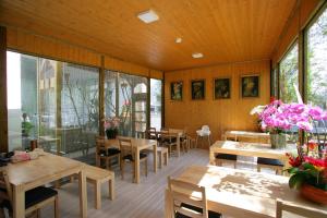 大湖乡夏内尔落羽松民宿的餐厅设有木桌、椅子和窗户。