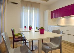 萨莱诺Mare di Luci的一间带桌椅和紫色橱柜的用餐室
