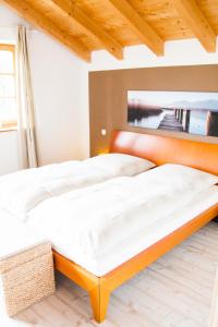 里姆斯廷格Hinterlechnerhof的卧室内的一张床位,配有木制床头板