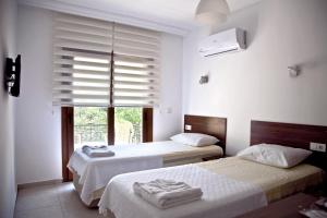 雅丽丝弗里克Şahin Motel & Restaurant的一间卧室设有两张床和一个带百叶窗的窗户。