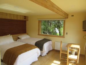达卡卫Hostal Casa Bosque的一间卧室设有两张床和窗户。