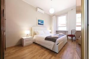 米兰Milan Retreats的卧室配有白色的床和红色椅子