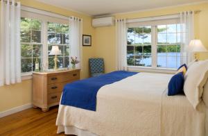 Poland Spring沃尔夫湾酒店 的一间卧室设有一张大床和两个窗户。