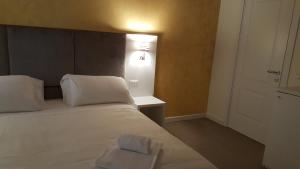 威尼斯精英之家旅馆的卧室配有白色的床和墙上的灯