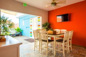 威廉斯塔德Bed & Bike Curacao的一间拥有橙色墙壁和桌椅的用餐室