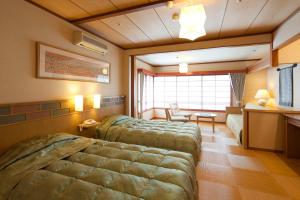 松江市南花粋苑旅馆的一间卧室配有两张床、一张桌子和一张书桌