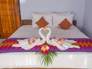 珀尼达岛Bintang Hostel and Homestay的床上用毛巾制成的两天鹅