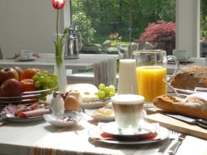埃尔克拉特佳斯特豪斯瓦恩穆勒酒店的早餐桌,包括早餐食品和橙汁