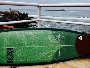 蒙达卡Mundaka Vista Mar L-BI-52的绿色冲浪板坐在俯瞰大海的阳台
