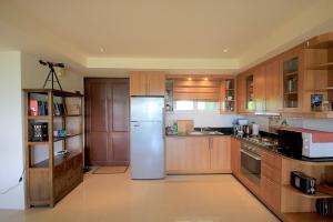 考陶Sea Ridge Penthouse by baansiesom的厨房配有不锈钢冰箱和木制橱柜