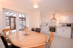 南安普敦Town or Country - Jessie Terrace House B的厨房以及带木桌和椅子的用餐室。