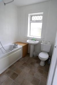 基尔马诺克Ayrshire cottage的带浴缸、卫生间和盥洗盆的浴室