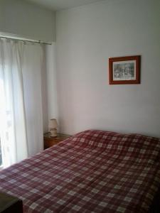 马德普拉塔Panoramico Playa Grande -Solo Familias的卧室配有一张床,墙上挂着一幅画