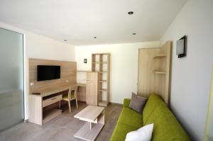 卡斯泰尔贝洛Panoramahof的客厅配有绿色沙发和书桌