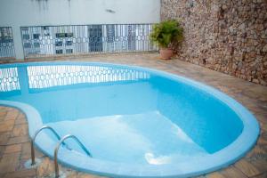 戈亚尼亚Flat Oeste La Residence的大楼内带蓝色浴缸的大型游泳池