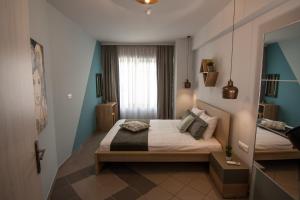 雅典Dynasta Central Suites的一间小卧室,配有一张床和镜子