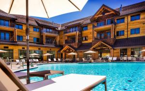 南太浩湖Zalanta的酒店游泳池配有桌椅和遮阳伞