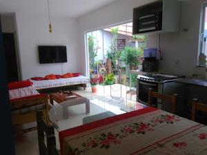 卡拉瓜塔图巴Caraguatatuba的厨房以及带餐桌和餐桌的起居室。