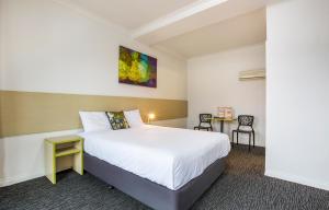 奥尔伯里回旋镖酒店的酒店客房配有一张床铺和一张桌子。