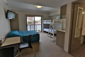 悉尼史卓菲行政住宿酒店的小房间设有一张床、一张桌子和一张桌子