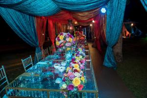 佩雷拉El Lugar Boutique Hotel的长桌,布满蓝色和红色的窗帘和鲜花