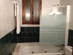 CoratxarHostatgeria Sant Jaume的浴室配有绿色瓷砖和浴缸